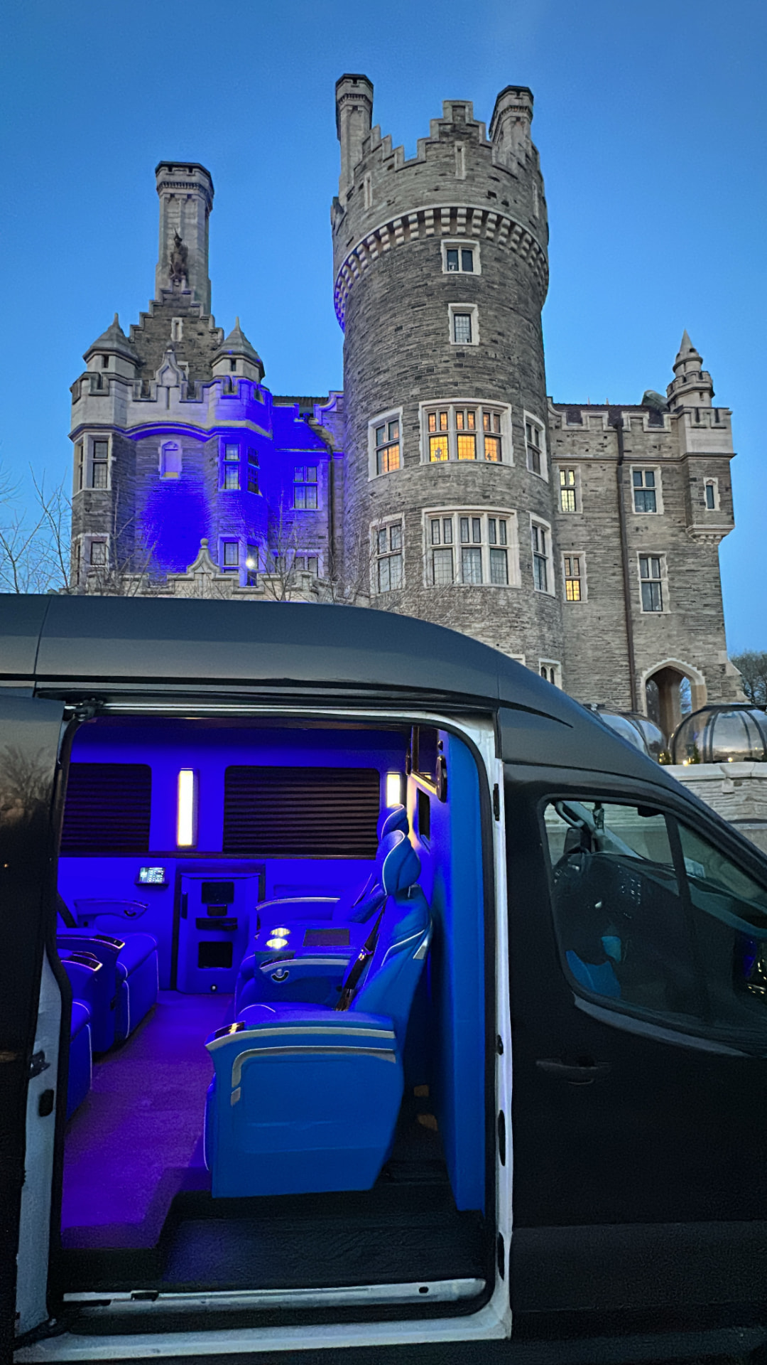 Black Mercedes-Benz Sprinter executive van at Casa Loma with blue ambient lighting