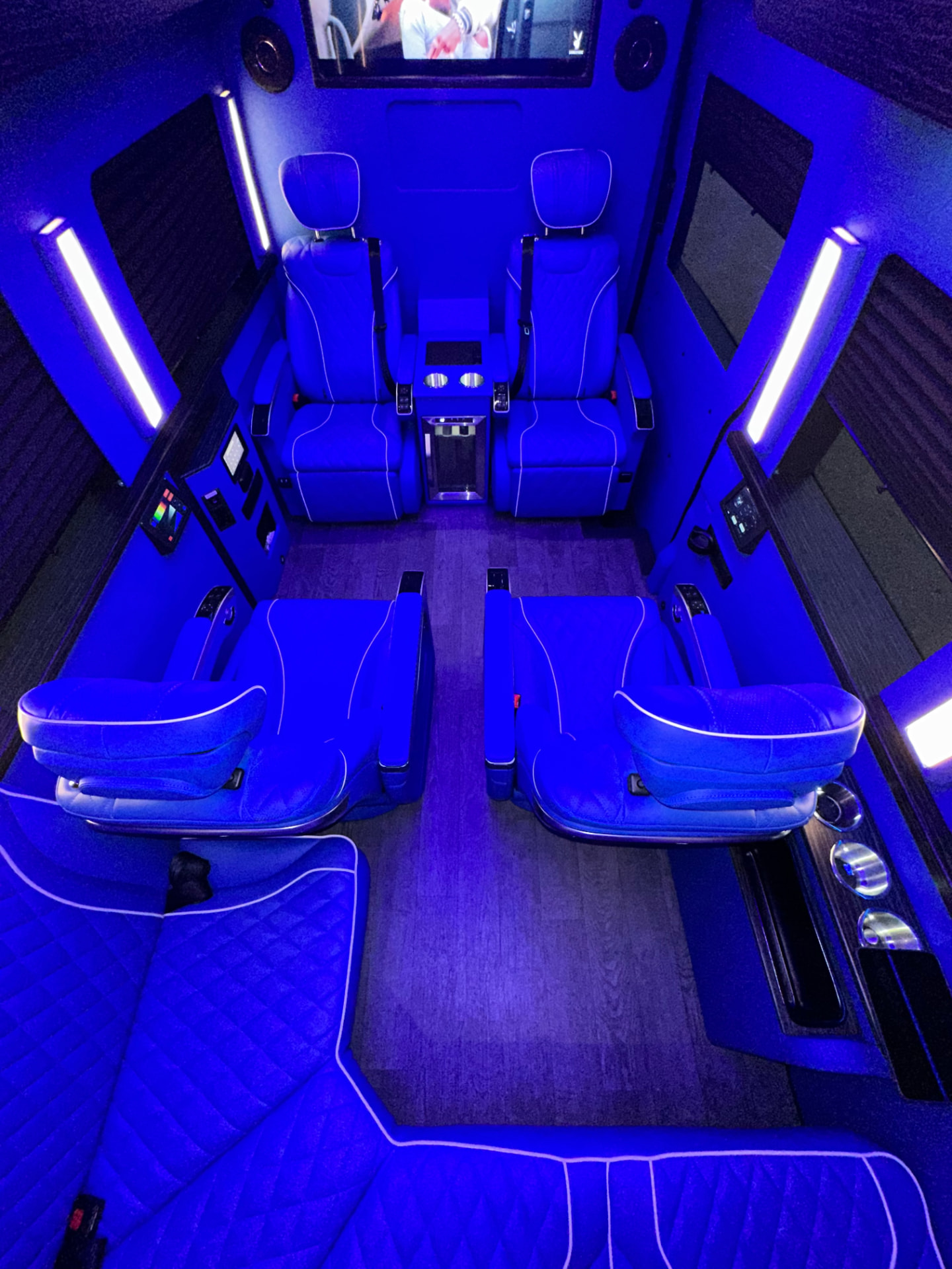 Sprinter interior with executive captain seats under blue ambient lighting