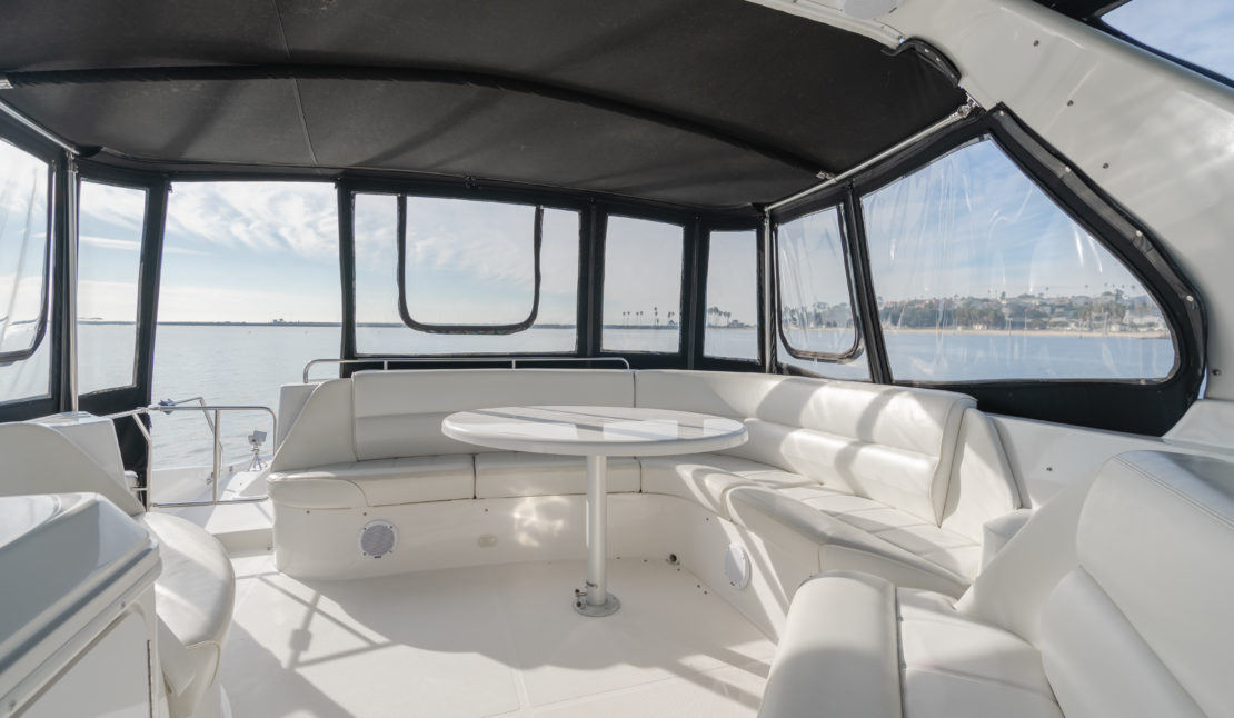 Enclosed flybridge of the 65ft Carver yacht with white leather seating