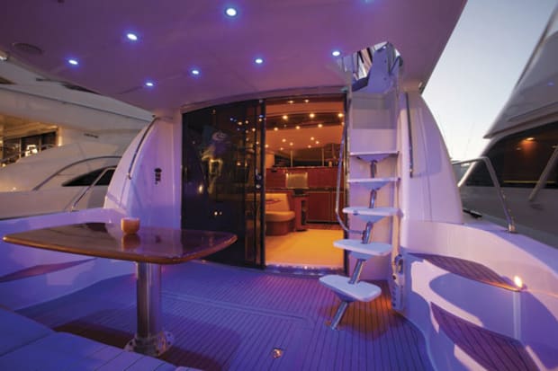 Aft deck of the 60ft Carver yacht lit at night with teak table